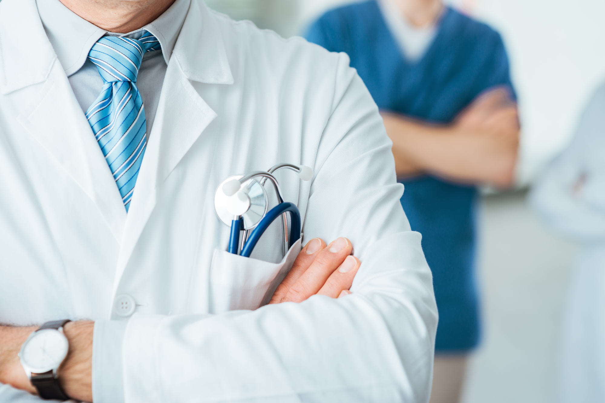 Professional medical team posing, doctor's lab coat and stethoscope close up, selective focus